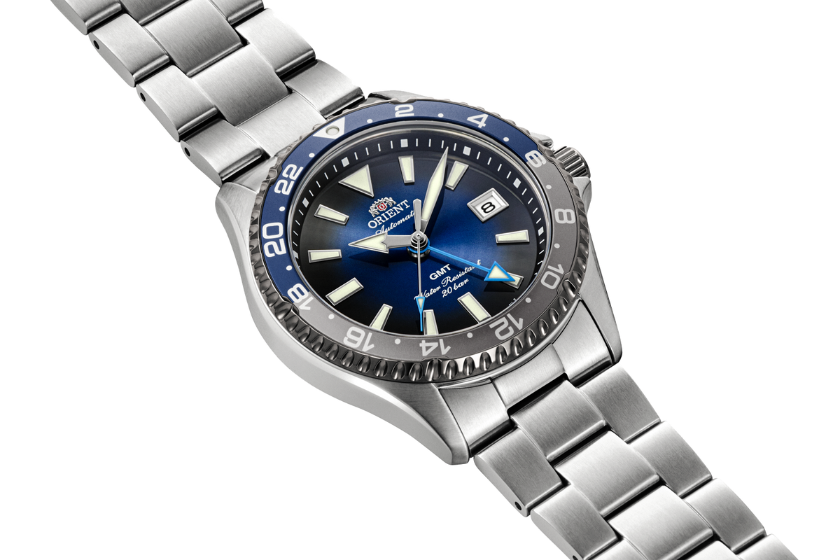 Angled view of the Orient RA-BC0005L Kamasu GMT watch with a blue gradient dial, blue-and-gray 24-hour bezel, and stainless steel case and bracelet