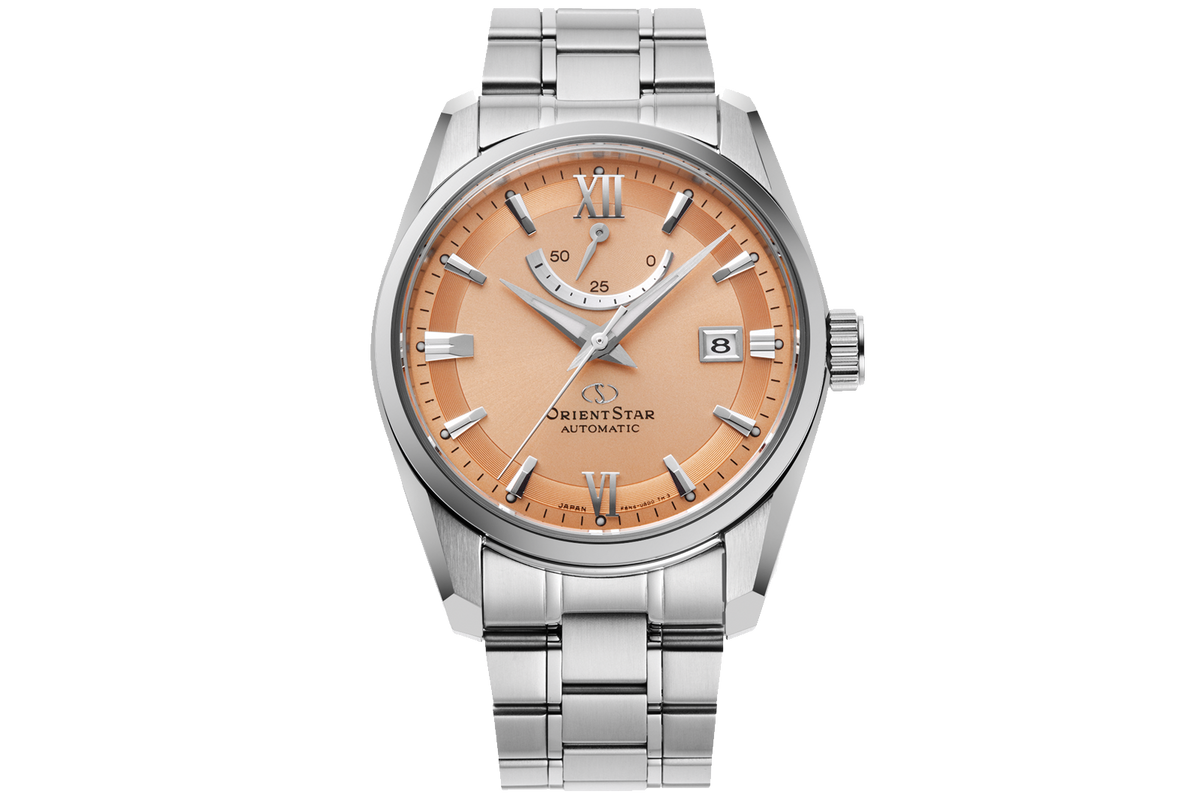 An Orient Star Automatic watch with a silver stainless steel bracelet and case, featuring a warm peach-orange dial with silver-tone indices and Roman numerals.

Orient Star RE-AU0108G