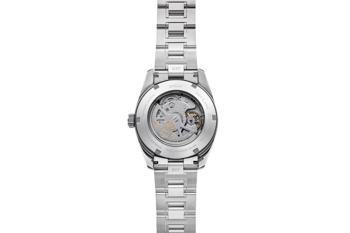 A stainless steel wristwatch shown from the back, featuring a transparent case back that reveals a detailed mechanical movement with gold and purple accents.

Orient Star RE-AU0108G