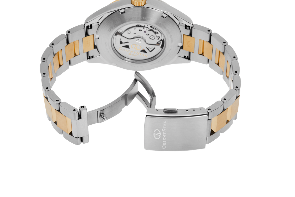 Close-up of the back of a two-tone stainless steel and gold watch with a visible automatic movement and a fold-over clasp

Orient Star RE-AU0405E